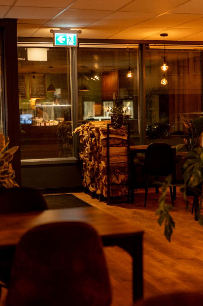 Inside CozyHaus in the evening, warm light and wood tables
